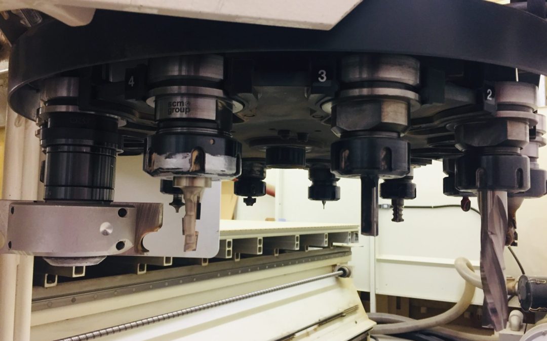 Close-up of CNC Machining Service tool changer and spindle head with various cutting bits for Precision CNC Routing of bespoke cabinetry components.
